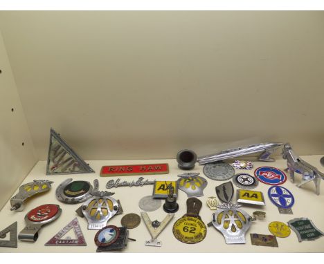 A collection of 26 motoring/car badges, a Rocket mascot and an Ariel Centenary nut cracker 