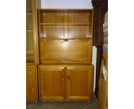 A modern Ercol light elm cabinet/shelves unit, the upper section fitted with a shelf above, on hinged drop-down door and two 