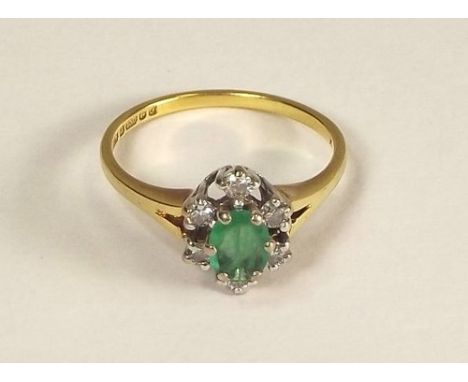 GOLD RING.
An 18ct. gold emerald & diamond cluster ring.
