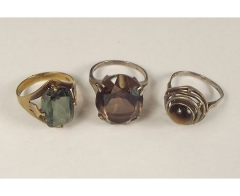 DRESS RINGS.
Two silver dress rings, one set a smoky quartz, the other a tiger's eye & a base metal dress ring.