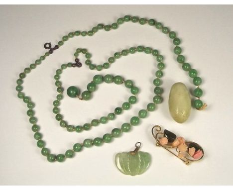 JADE JEWELLERY.
A double strand of green jade beads (for re-threading), a pale mottled jade pendant, a jade & coral brooch et