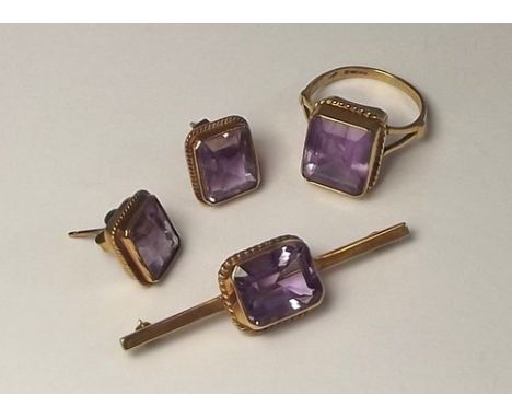 AMETHYST SUITE.
A 9ct. gold & amethyst bar brooch, matching earrings & a similar 9ct. gold amethyst dress ring.