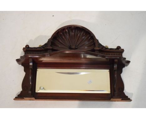 Early 20th Century mahogany wall bracket having carved shell design cresting with serpentine front shelf and bevelled mirror 