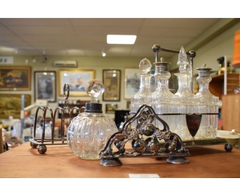 Early 20th Century silver plated six bottle cruet set, silver plated toast rack and an alpaca white metal napkin holder and g