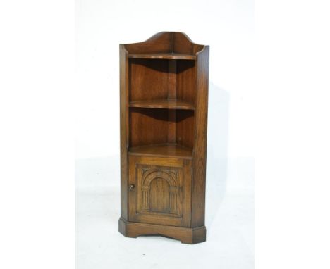 Reproduction oak standing corner cupboard fitted three open shelves with a cupboard door below and standing on bracket feet  
