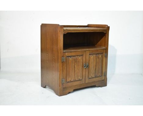 Reproduction oak side cabinet fitted one shelf with under tier and two linen fold panel doors below   Condition: 
