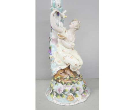 A German porcelain figural candlestick with floral relief detailing to base 
