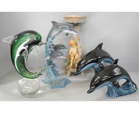 A collection of assorted items including two Poole Dolphin figures, a glass dolphin, a ceramic Riding the Wave figure by Mike