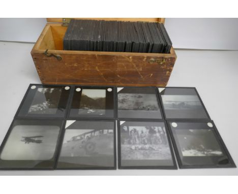 A box of 74 Edwardian lantern slides including bi-planes, tiger kill, Indian military life, mountaineering, etc. *THIS LOT IS