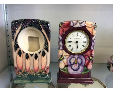 Two Moorcroft mantle clock cases, one with Moorcroft clock fitting with white enamel and Roman numerals.