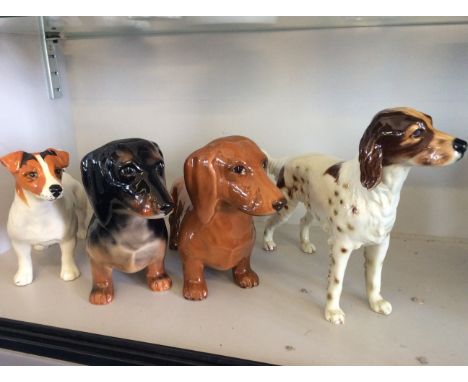 Three Beswick and one Goebel and Hummel dog figurines.