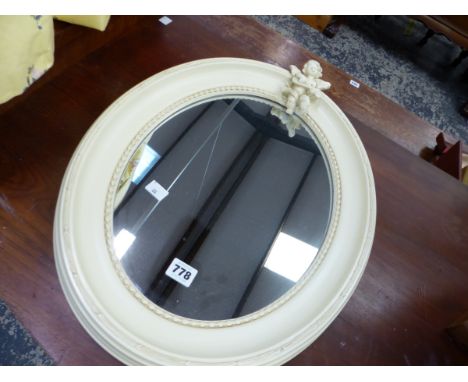 A OVAL MIRROR WITH CHERUB SURMOUNT. 