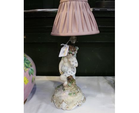 Continental lamp base decorated with a cherub marked to the base with blue crossed swords