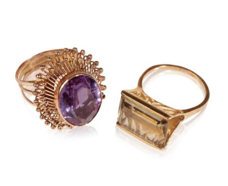 AMETHYST DRESS RING AND ONE OTHER "SMOKEY QUARTS RING", the oval-cut faceted amethyst, raised on a spray setting, with triple