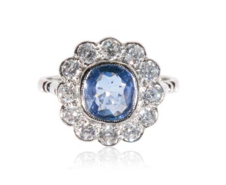 SAPPHIRE AND DIAMOND CLUSTER RING, the collet-set sapphire, approx 1ct, surrounded by a border of twelve brilliant-cut diamon