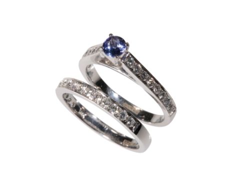 TANZANITE AND DIAMOND RING, the raised claw-set tanzanite, on a white gold shank stamped "750", with diamond set shoulders, r