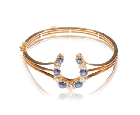 SAPPHIRE AND DIAMOND BANGLE, six graduating sapphires, interspersed with five graduating diamonds, the centre diamond approx 