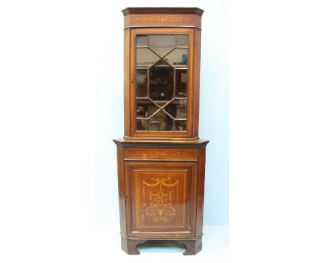 An Edwardian marquetry and mahogany standing corner cupboard, the top with single glazed door above a single panelled door en