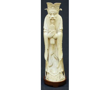 A Qing Dynasty carved Chinese ivory figure of Luxing or Ts'ao Kuo-Chiu, modelled wearing court dress and holding a castanet, 