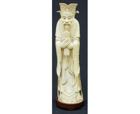 A Qing Dynasty carved Chinese ivory figure of Luxing or Ts'ao Kuo-Chiu, modelled wearing court dress and holding a castanet, 