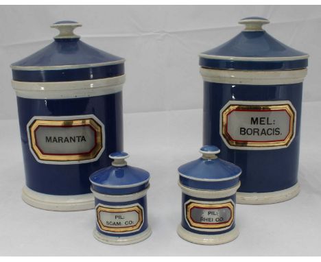 Two large blue and white glazed ceramic apothecary jars with covers, 24cm high, and two small examples, 10cm high, with print