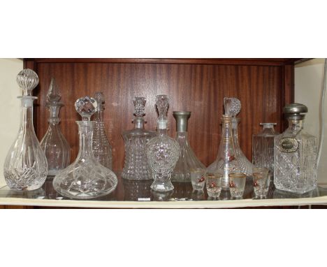 A collection of 10 cut glass decanters, including three ships decanters and others of varying shapes and sizes, together with