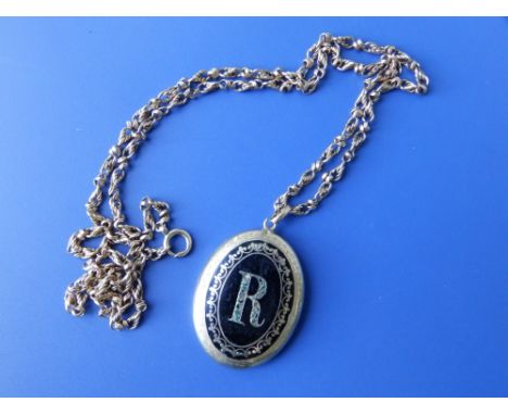 An oval black enamel locket decorated with the letter 'R' on chain.