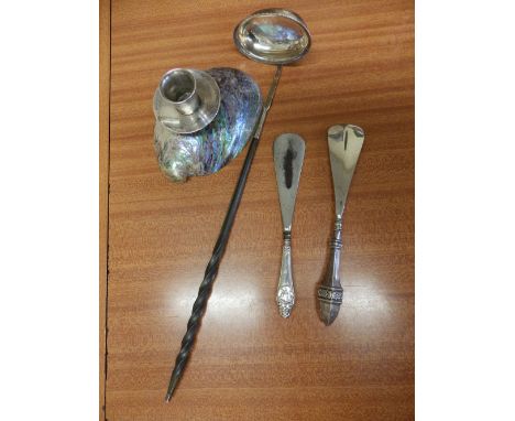 A punch ladle, two silver-handled shoe horns and a modern New Zealand shell candlestick. (4)