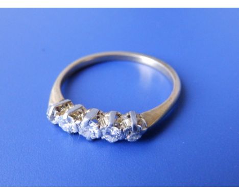 A five stone graduated diamond ring in yellow metal – finger size P.
