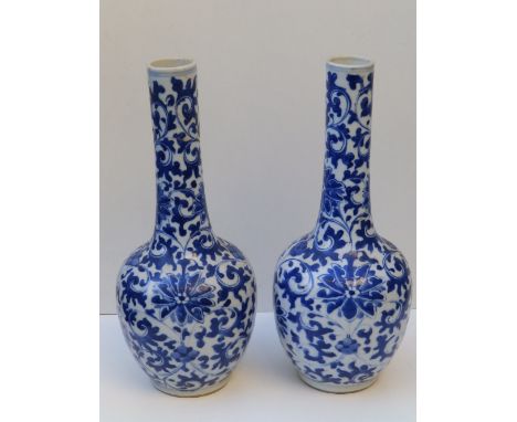 A pair of Chinese blue &amp; white porcelain bottle vases decorated overall flowerheads within arabesque leaf scroll, concent