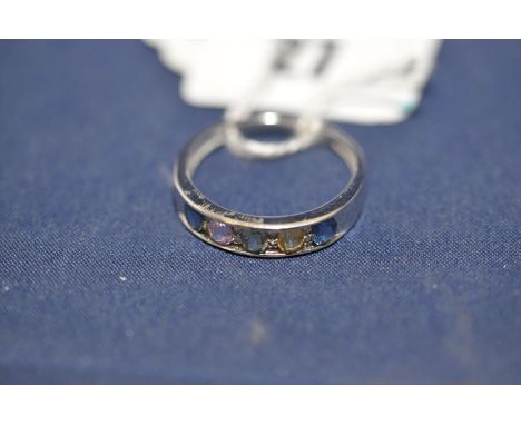 A gemstone and diamond ring, in channel setting, on 9ct. white gold shank, ring size R.