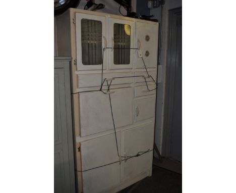 A 1950's cream painted kitchen cabinet, fitted an arrangement of doors, drawers and cupboards, with fold-down sliding enamel 