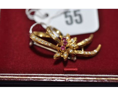 A ruby, diamond and 18ct. yellow gold flower pattern brooch, 7.9grms gross.