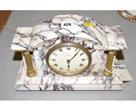 A first half 20th Century stained white marble mantel clock, fitted French movement retailed by Reid & Sons, 26cms wide.