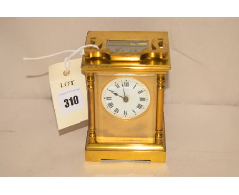 A 19th Century brass carriage clock, open escapement, white enamel roman dial.