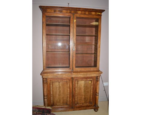 A 19th Century mahogany bookcase, the flared cornice above glazed panel doors enclosing adjustable shelving, the plain panel 