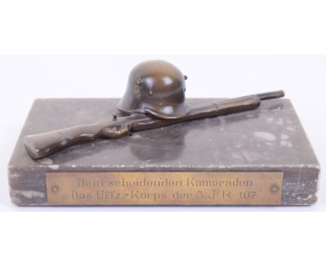 Third Reich Desk Ornament, being a rectangular marble base having bronzed German helmet laying over rifle to the centre. Moun