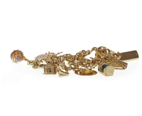 GOLD CHARM BRACELET, with a heart shaped clasp, the charms including a ship, a whisky bottle, a hat and a lantern, most marke
