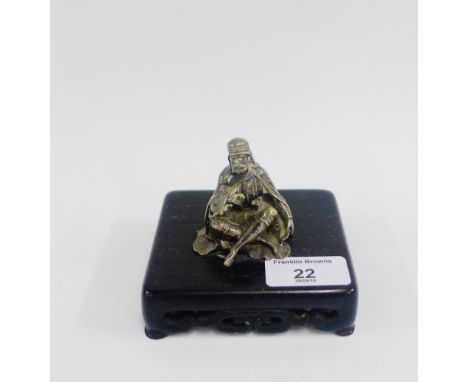 White metal 'Arab' desk paperweight on a chinoiserie wooden base, 10cm wide 