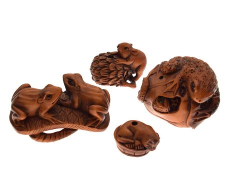 Four Japanese carved boxwood netsuke, comprising; two frogs on a sandal (waraji), 50mm long; a toad atop a squash or melon, a