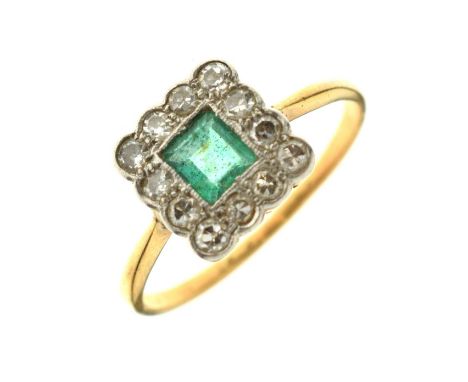 Early 20th century emerald and diamond yellow gold and platinum set cluster ring, the square step cut emerald measuring appro