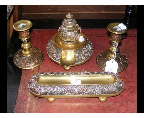 A brass and copper Victorian desk set comprising inkwell, pen stand and a pair of candlesticks