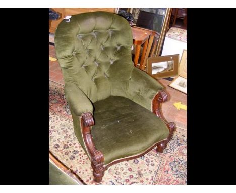 An antique button back armchair on castors 