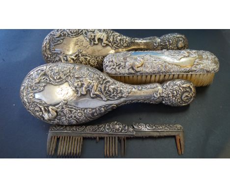 A pair of repousse silver hair brushes; together with a similar hair brush and comb.