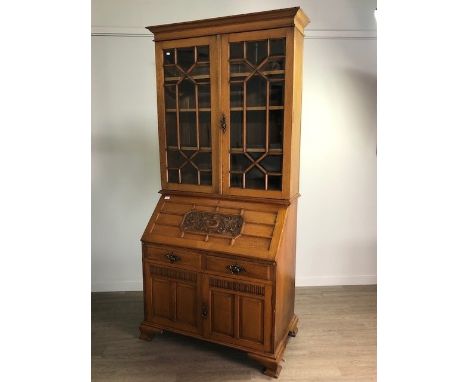 LATE VICTORIAN OAK BUREAU/BOOKCASE, with moulded cornice over two astragal glazed doors, the fall front writing surface mould