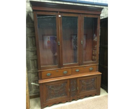 LATE 19TH CENTURY WALNUT BOOKCASE, the moulded cornice over three glazed doors and two short drawers, the base with two carve