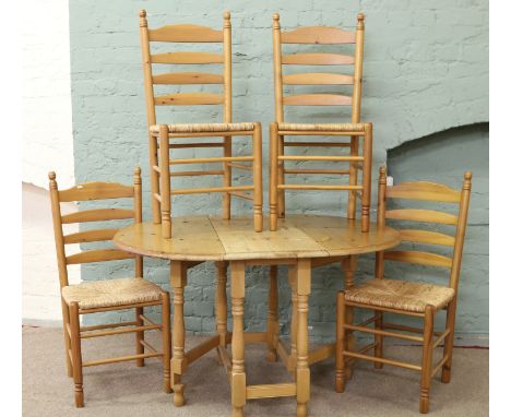 A pine dropleaf table and a set of four rush seat ladder back chairs.