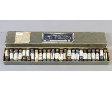 A box of vintage glass files of Reeves of London stained in various colours.