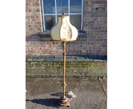 A 1920S TURNED WALNUT AND EBONISED STANDARD LAMP with cast iron feet, double lamp fitting and Chinoiserie shade, held with a 