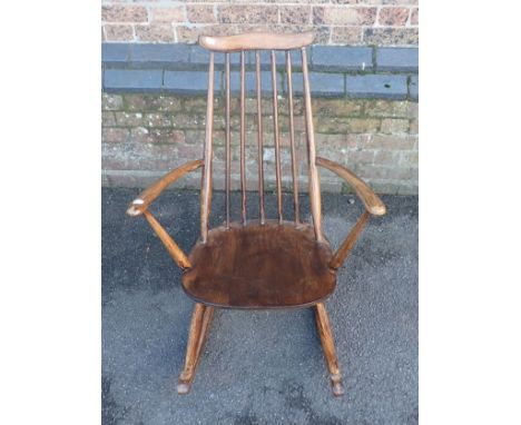 AN ERCOL ROCKING CHAIR (poorly re-varnished)